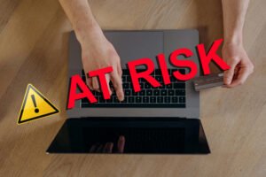 Online credit card data at risk — warning sign with hands using laptop and holding card, cybersecurity and fraud alert concept